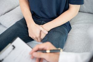 a person sitting on a couch holding a pen