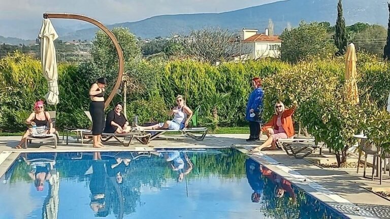 Guests relaxing by the pool with the hills behind