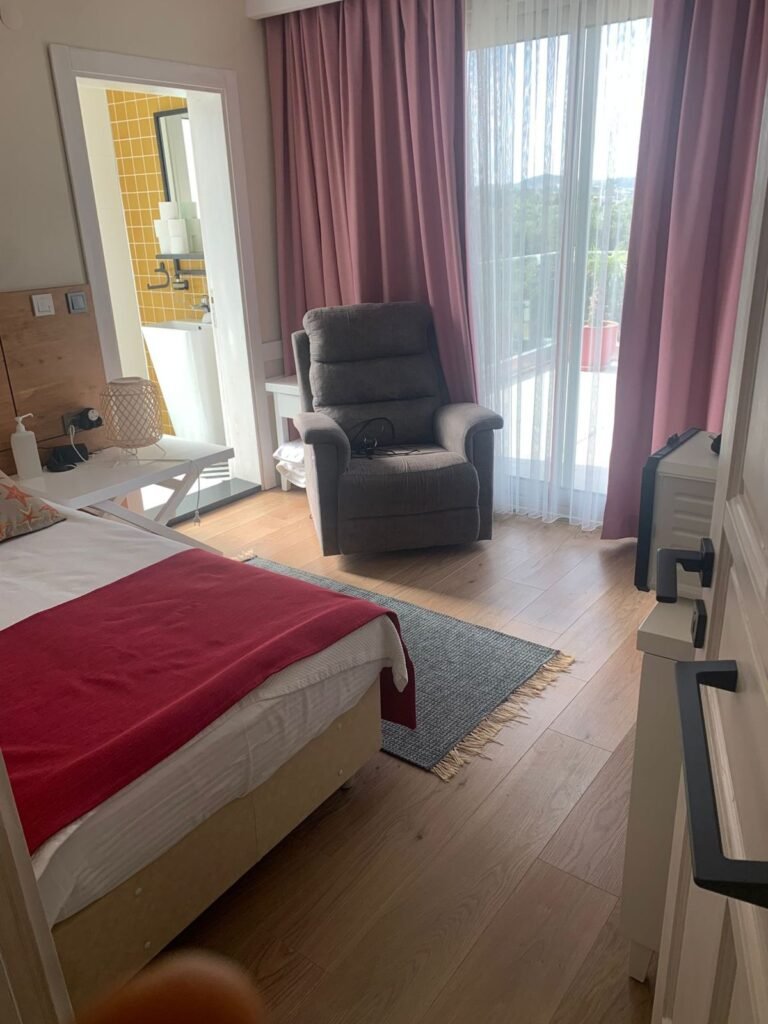 A guest room with armchair and garden view at Mandarin Grove